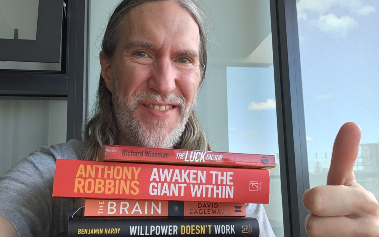 Portrait of Anthony Metivier with best willpower books in a stack